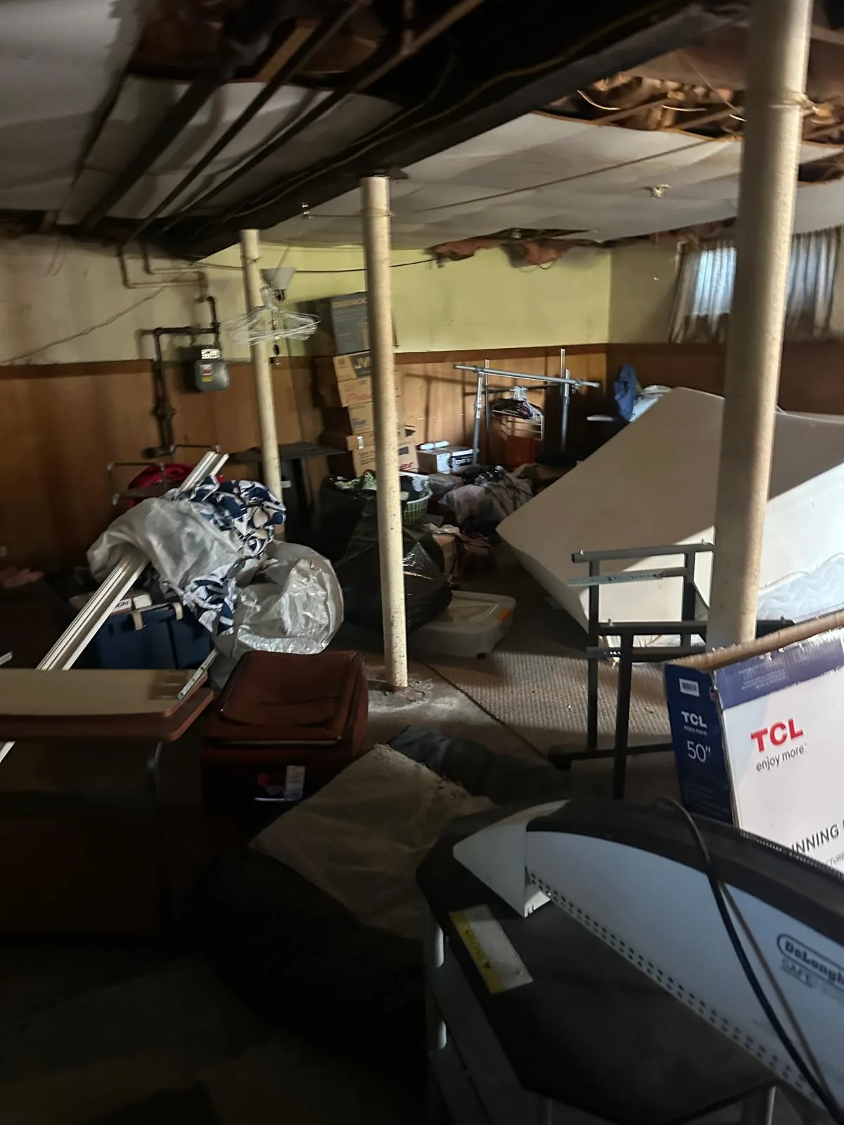 Basement packed with furniture and boxes before a cleanout in Rhode Island