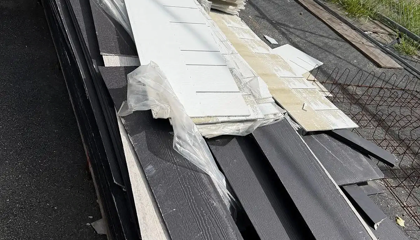 Stack of old siding and building debris in a lot before removal in Rhode Island