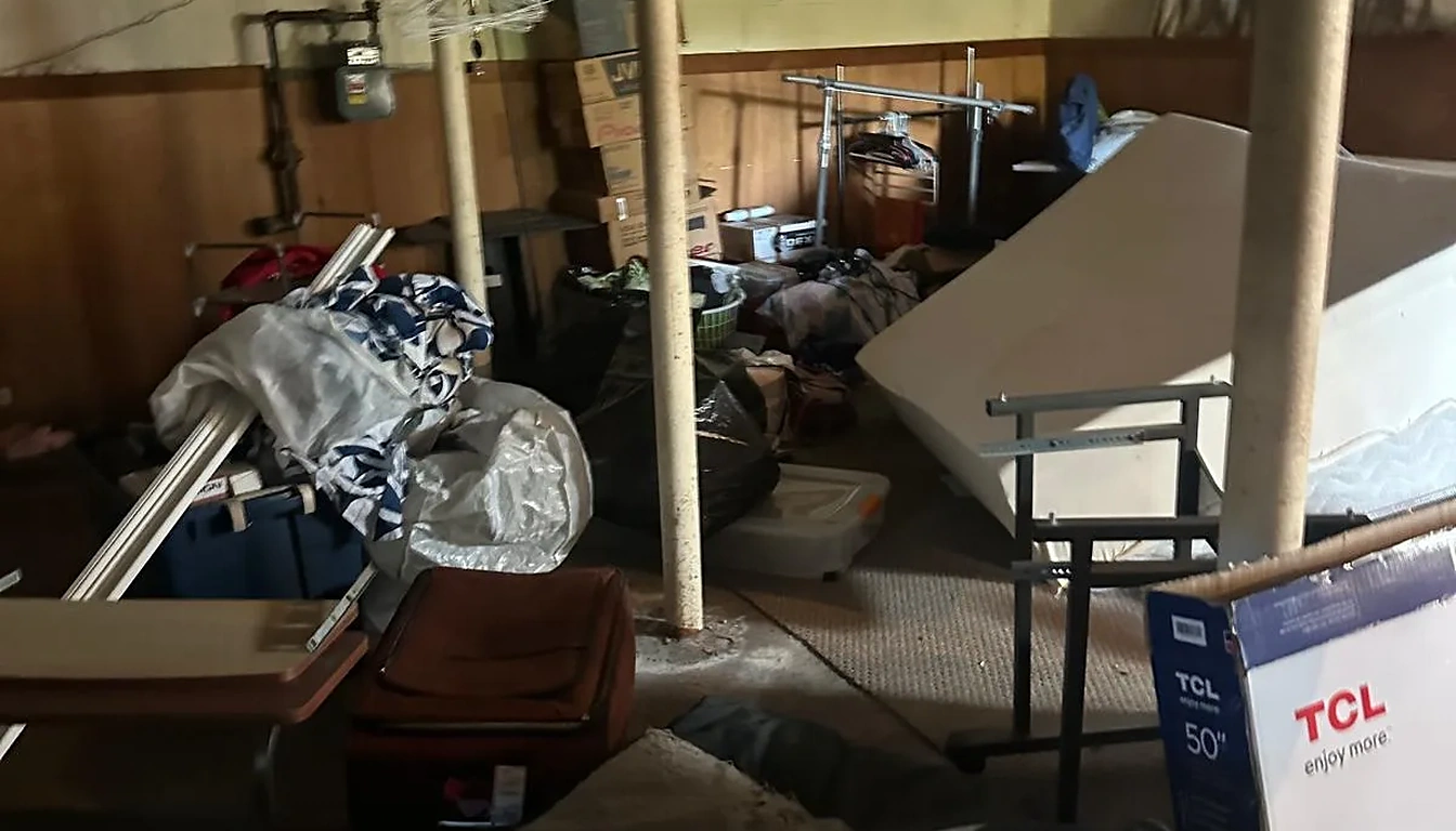 Basement packed with furniture and boxes before a cleanout in Rhode Island