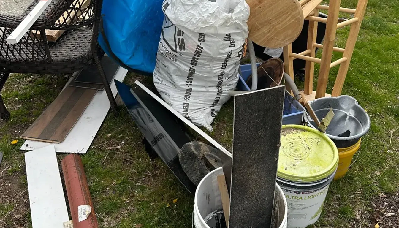 Kiddie pool, buckets and stools piled on a front lawn before removal