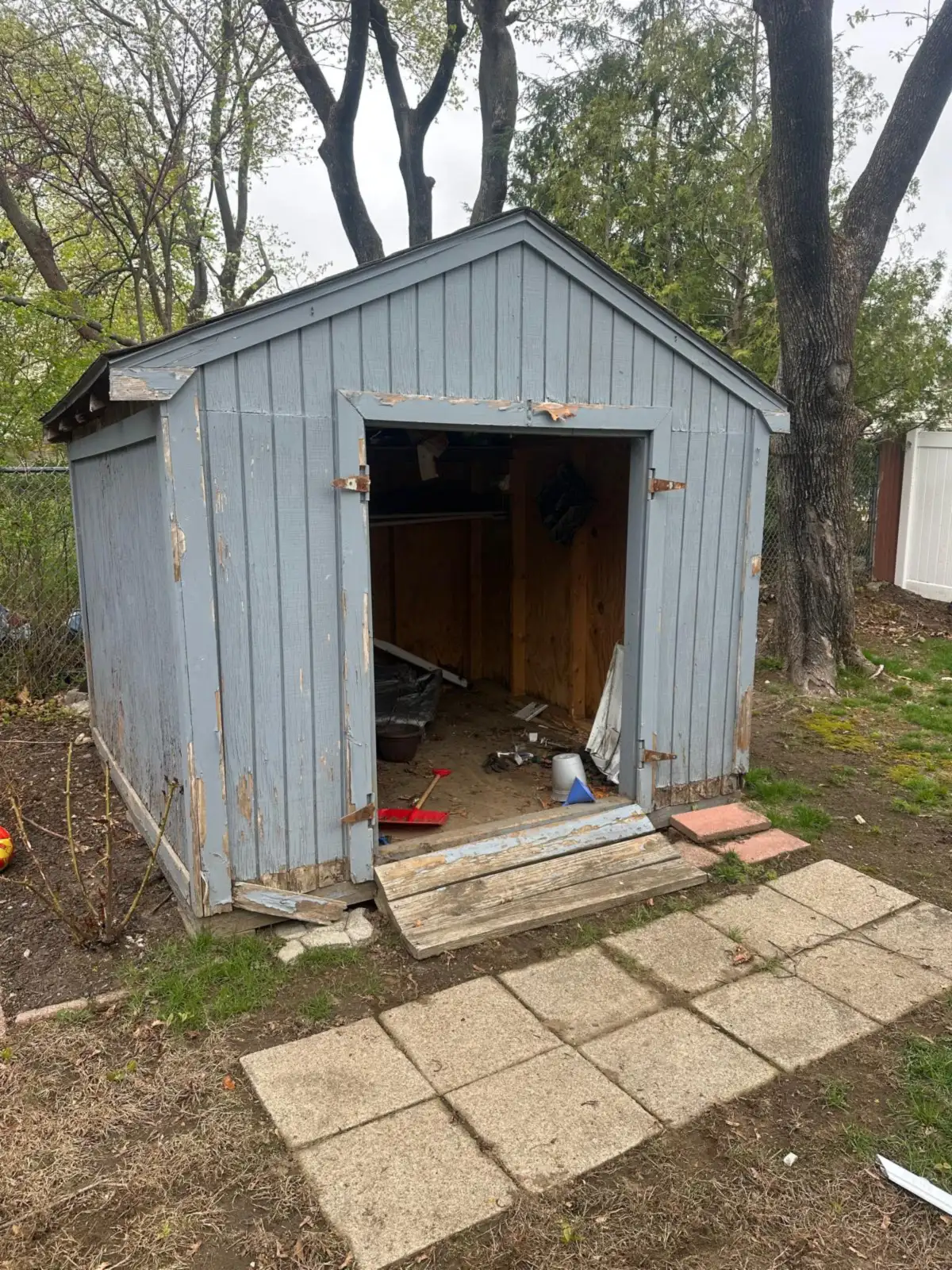 Old wooden shed with its door open before shed removal in Rhode Island
