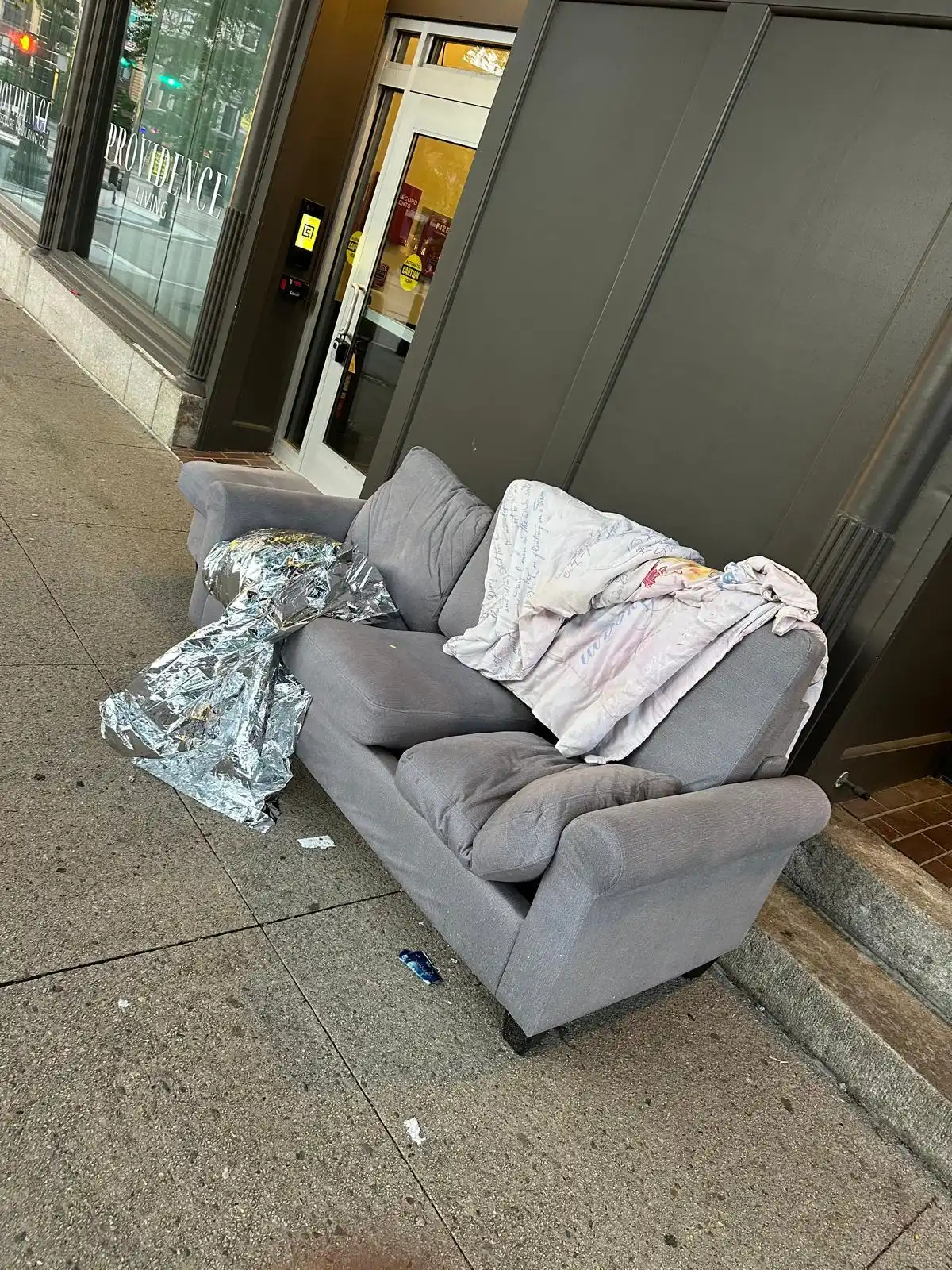 Old couch dumped outside a storefront before removal in Rhode Island